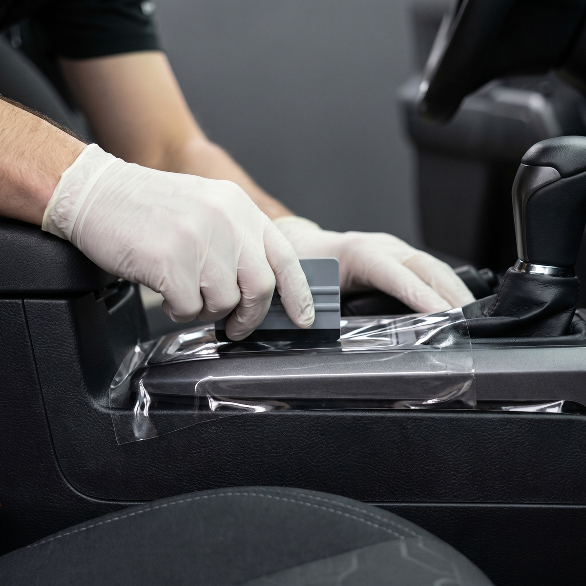 Protective film being applied to a vehicle interior panel